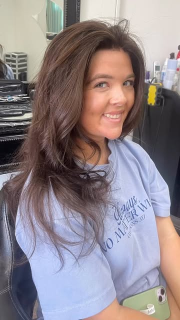 Smiling client with voluminous, glossy brunette waves