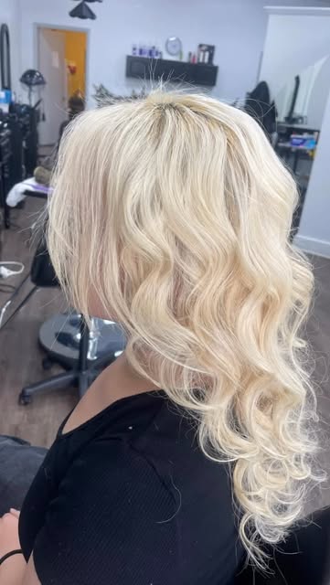Bright blonde hair styled in soft, bouncy curls