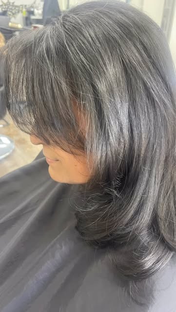 Shoulder-length layered cut with curtain bangs on dark hair