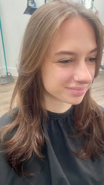 Long layered cut with soft face-framing pieces on light brown hair